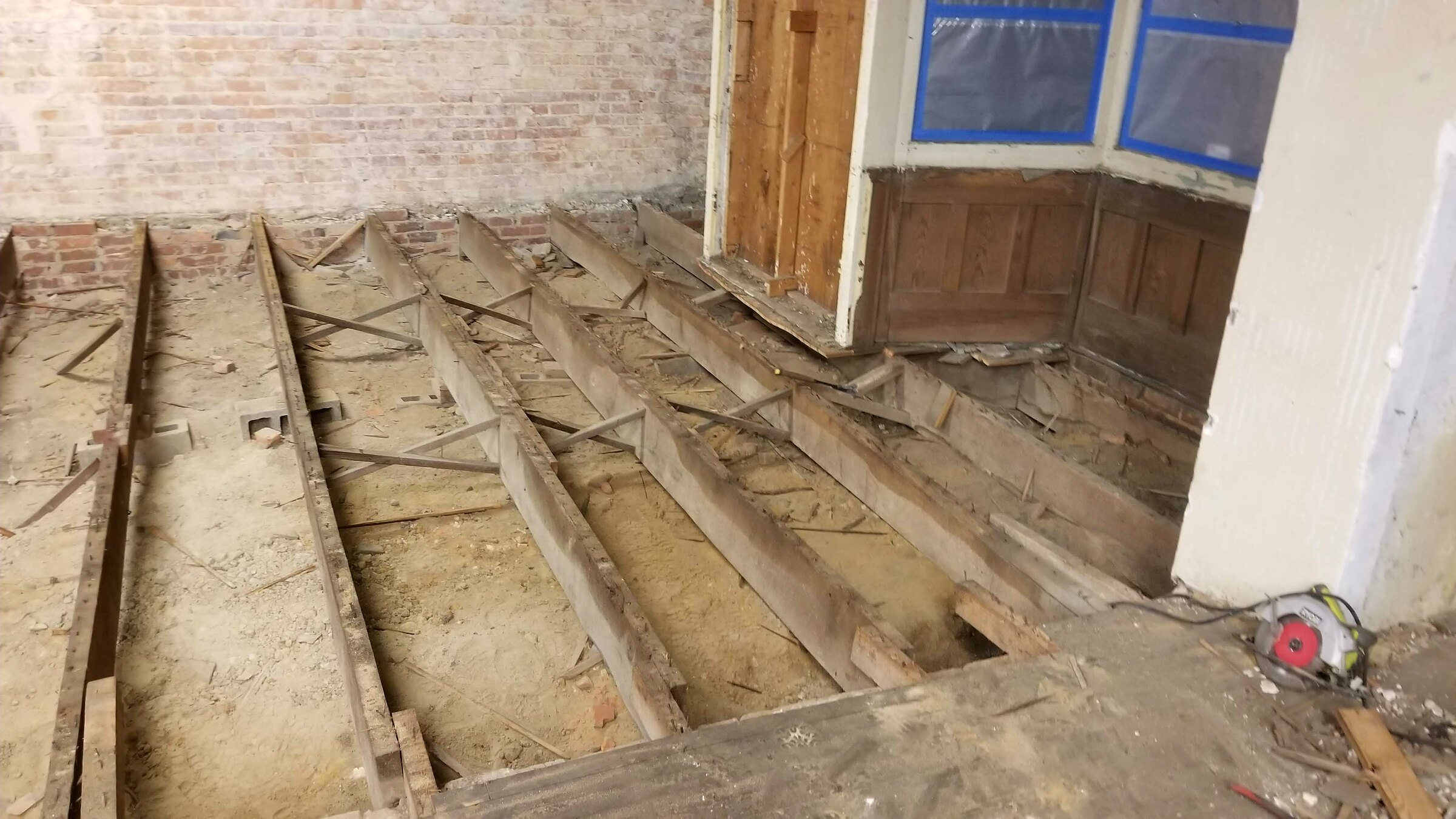 Original floor joists exposed during removal of the old flooring