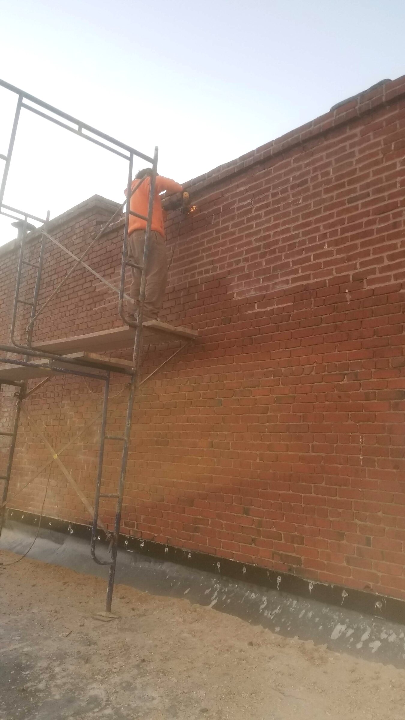 Brick exterior wall being repaired from scaffolding